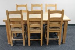 A light pine farmhouse dining room table and six ladder back chairs