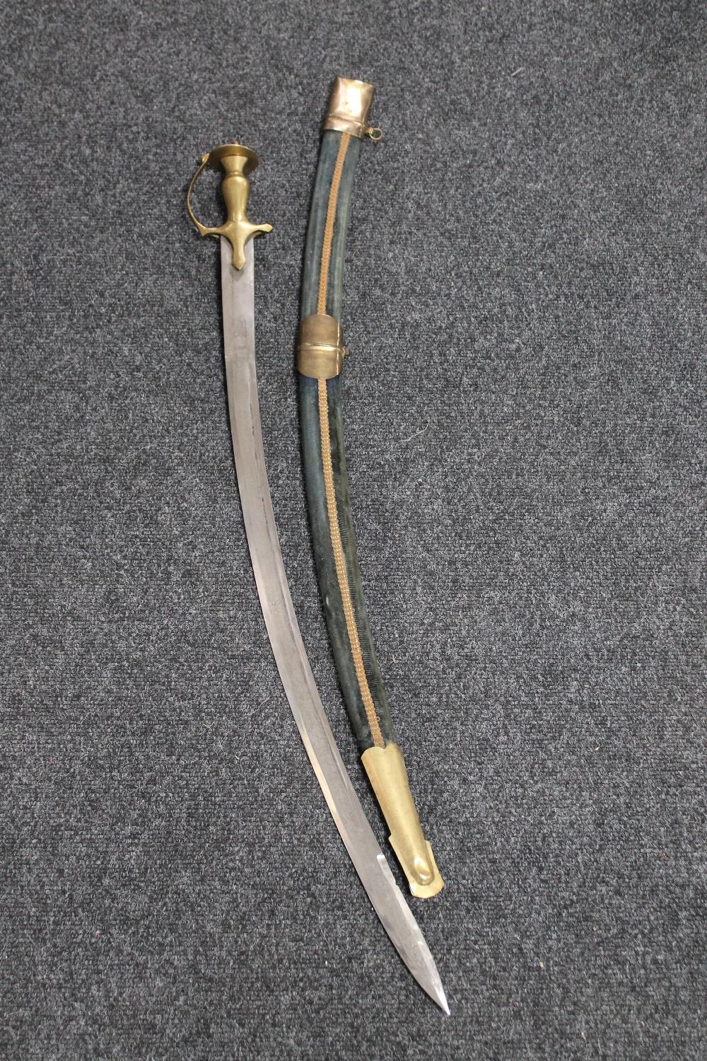 An Indian brass mounted sword in scabbard