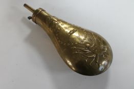 A brass shot flask with US Army emblem below eagle