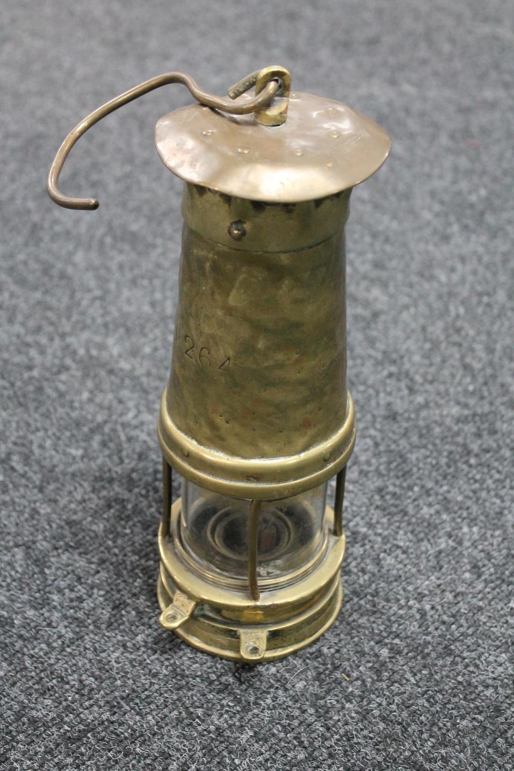 An antique brass miner's lamp numbered 1264