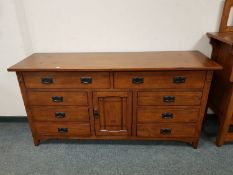 An oak Arts & Crafts style sideboard fitted drawers and a cupboard,