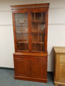 A yew wood glazed bookcase,