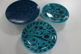 A pair of glazed pottery Turkish plates in a 16th century design and one other similar plate