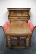 A carved oak refectory dining table together with four chairs upholstered in Burgundy fabric,