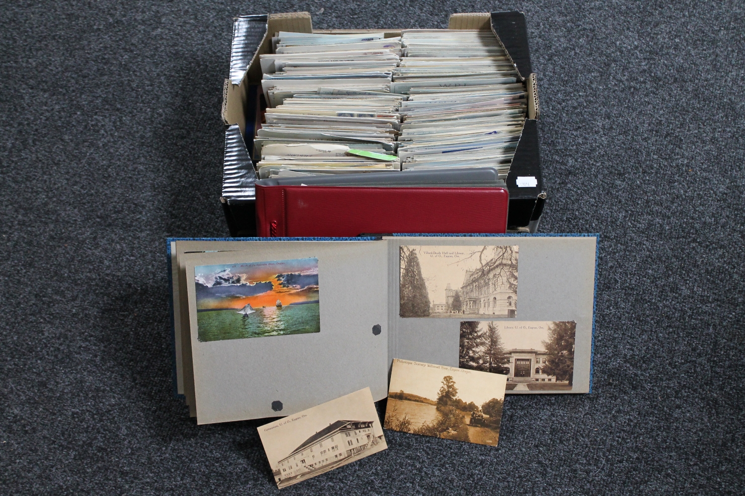 A box of 20th century postcards and two albums of postcards