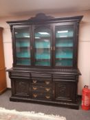 A Victorian carved and ebonised bookcase fitted cupboards and drawers beneath,