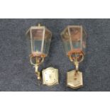 A pair of antique brass and copper coach house lanterns with wall mounts