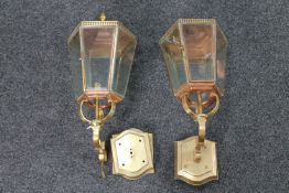 A pair of antique brass and copper coach house lanterns with wall mounts