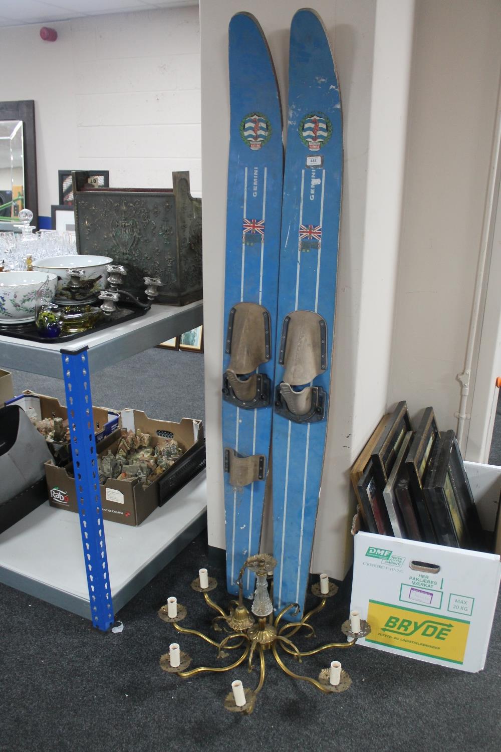 A set of wooden water skis and a brass chandelier