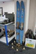 A set of wooden water skis and a brass chandelier