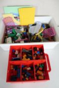 A red plastic storage box containing Lego building blocks and a crate of Lego System building kits