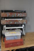 A pair of folding trestle stands together with a folding work bench and metal case,