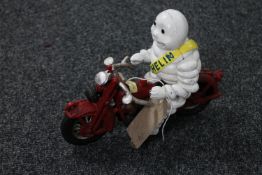 A cast iron figure of Michelin man on motorbike