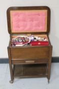 A mid twentieth century sewing trolley fitted with a drawer containing a large quantity of sewing