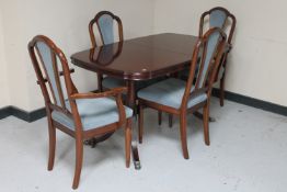 An inlaid mahogany shaped extending dining table fitted with a leaf and four chairs