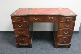 A mahogany writing desk fitted with nine drawers with three leather inset panels