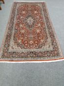 A Kashan rug, on red ground,