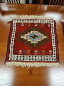 A Caucasian fringed mat on red ground 55 cm x 55 cm