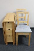 A contemporary pine drop leaf kitchen table with two chairs