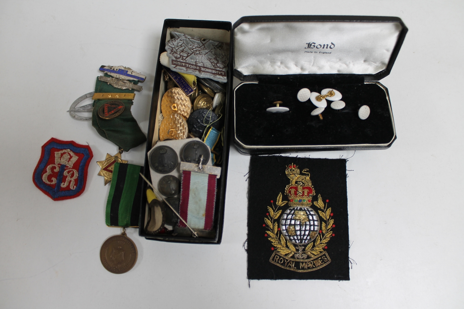 A collection of military badges and buttons, school badges,
