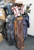 Four golf bags containing assorted irons and drivers