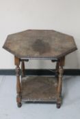 An octagonal Edwardian oak two tier carved occasional table