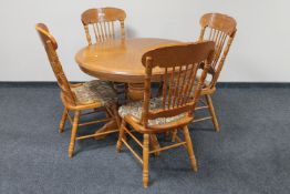 A circular oak pedestal American style extending table and four chairs