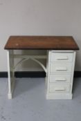 An Edwardian oak child's single pedestal desk fitted with four drawers and a slide