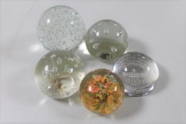 Five glass paperweights to include a Waterford crystal Stuart advertising paperweight