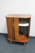 A mid twentieth century teak sliding door cocktail cabinet