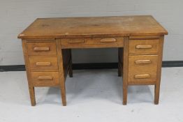 An early twentieth century oak twin pedestal desk fitted with six drawers