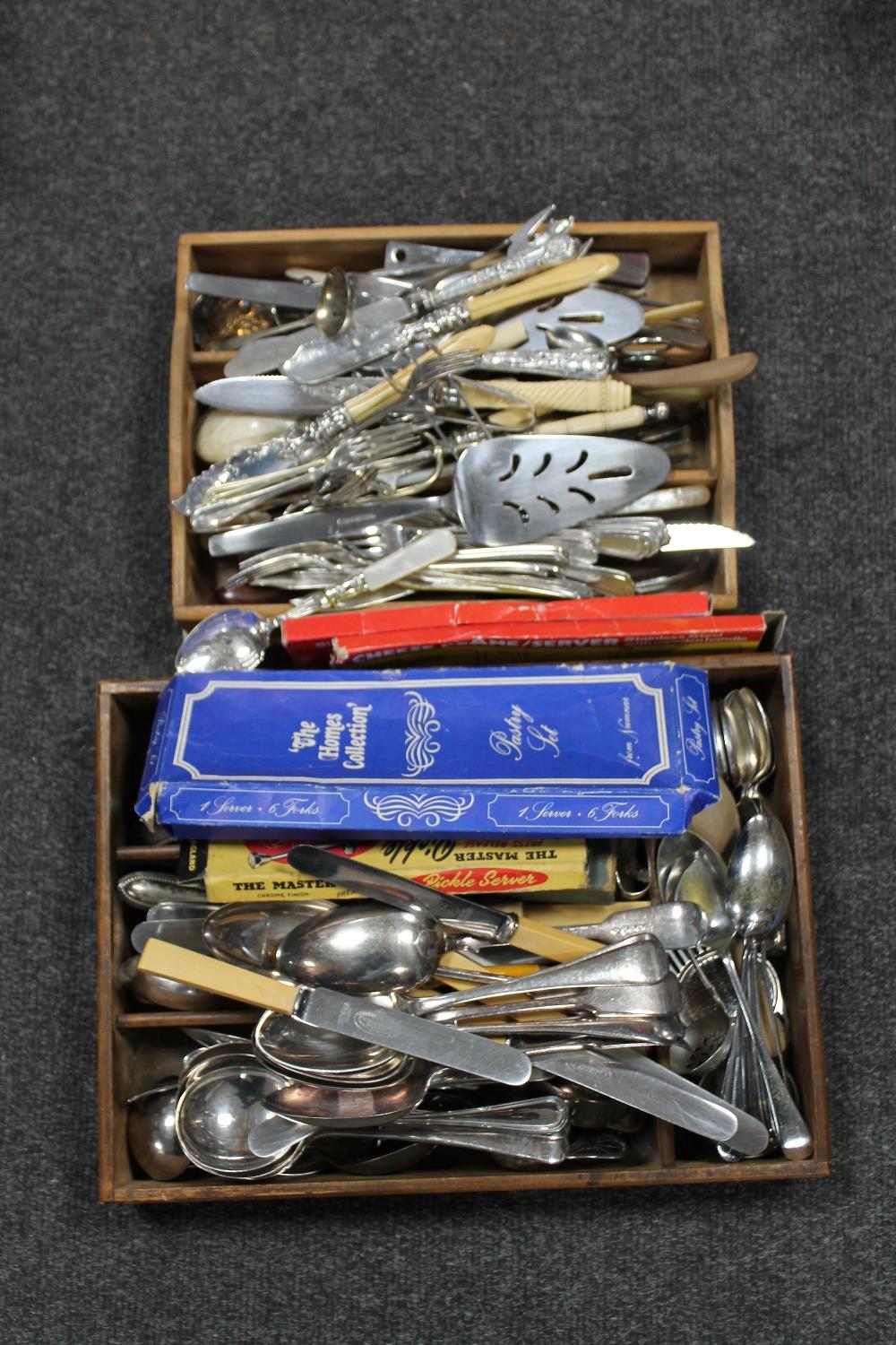 Two wooden cutlery trays containing cutlery,