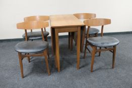 A mid twentieth century teak drop leaf table with four chairs