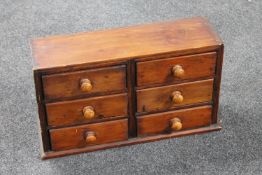 An antique pine miniature six drawer chest