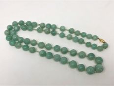 A Chinese apple green jade beaded necklace