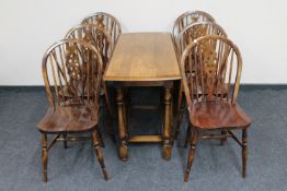 A 20th century oak gate leg table with a set of six wheel back chairs