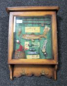 A fishing montage in glazed wall cabinet