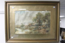 A gilt framed watercolour, Sheep by a river with dwelling beyond,