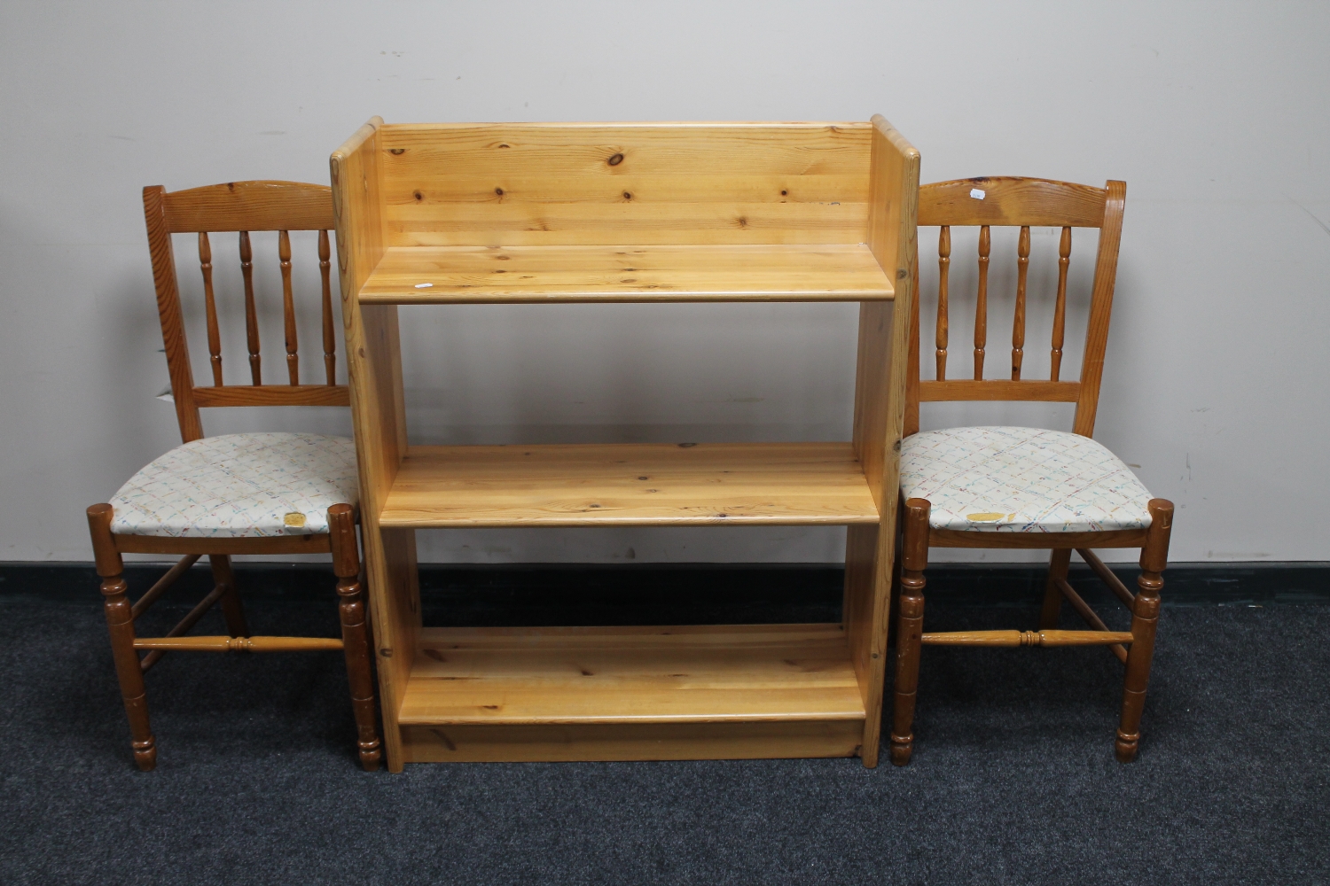 A set of pine open shelves and a pair of pine dining chairs
