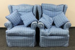 A pair of wingback armchairs upholstered in blue upholstery,