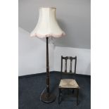 An early 20th century standard lamp and an oak Arts & Crafts bedroom chair