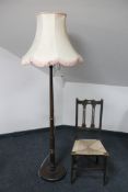 An early 20th century standard lamp and an oak Arts & Crafts bedroom chair