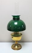 An antique brass Aladdin oil lamp with green glass shade and chimney