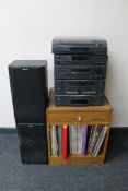 A Sony hifi system with speakers and remote on teak effect stand containing LP records and tapes