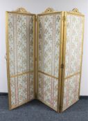 A gilt fabric upholstered three way folding screen