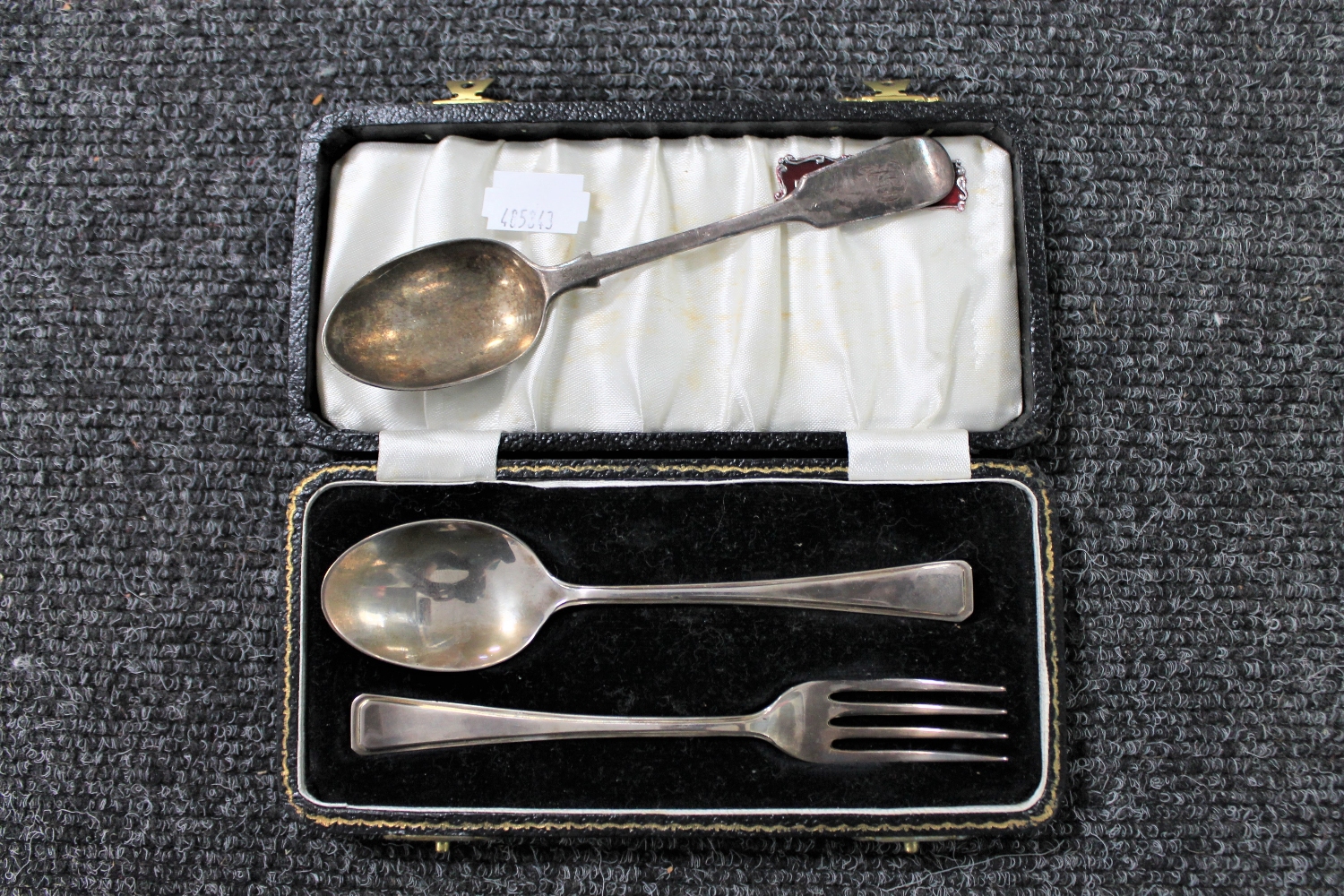 A cased silver baby spoon and fork together with a cased silver teaspoon