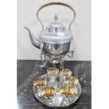 A good quality plated spirit kettle on paw feet with burner and wicker handle,