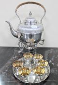 A good quality plated spirit kettle on paw feet with burner and wicker handle,
