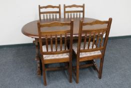 An oval extending dining table and four chairs