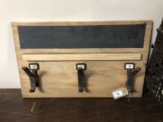 Three vintage cast iron coat hooks mounted on a board